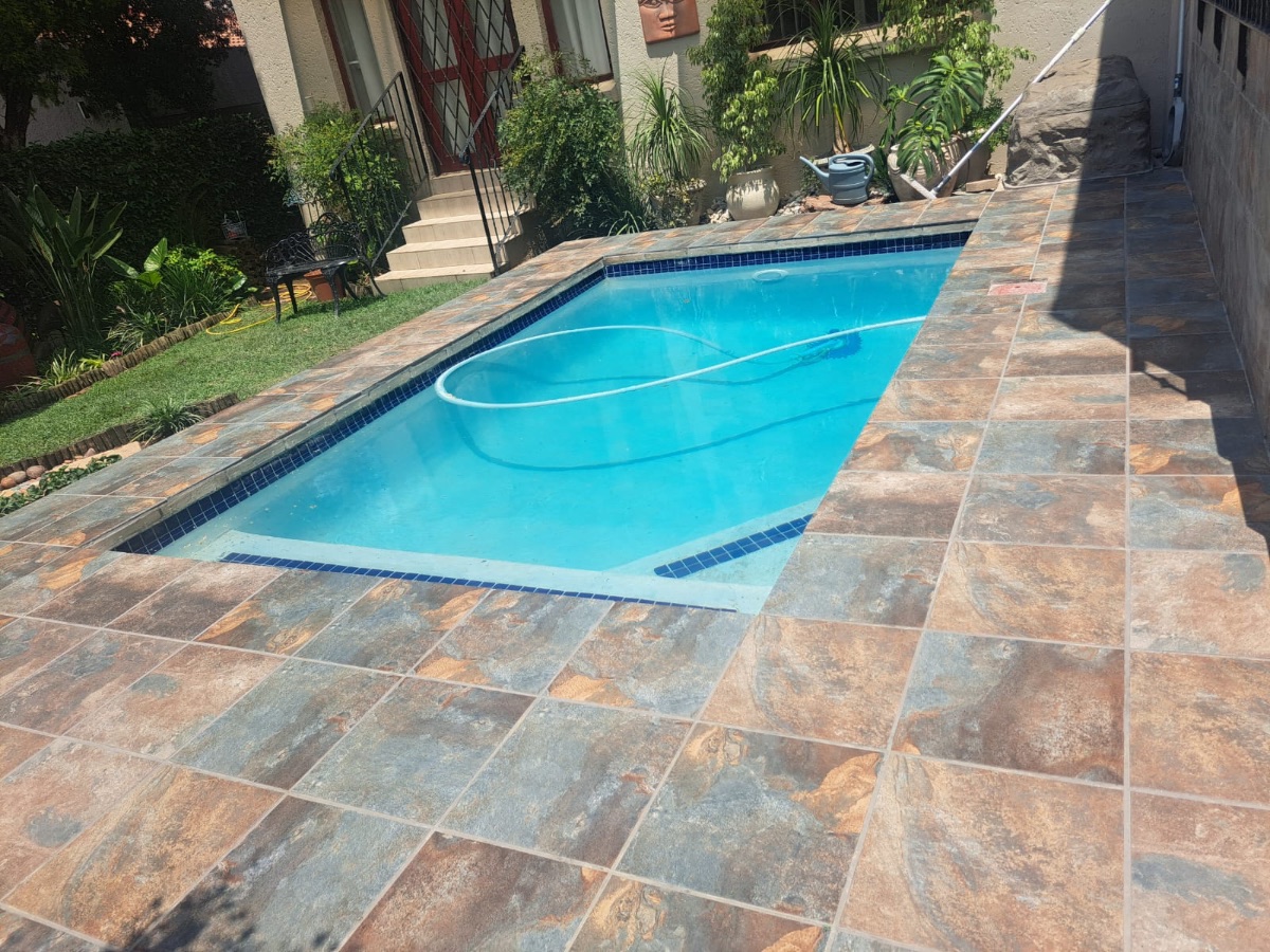Rectangular pool with stone-look tile paving